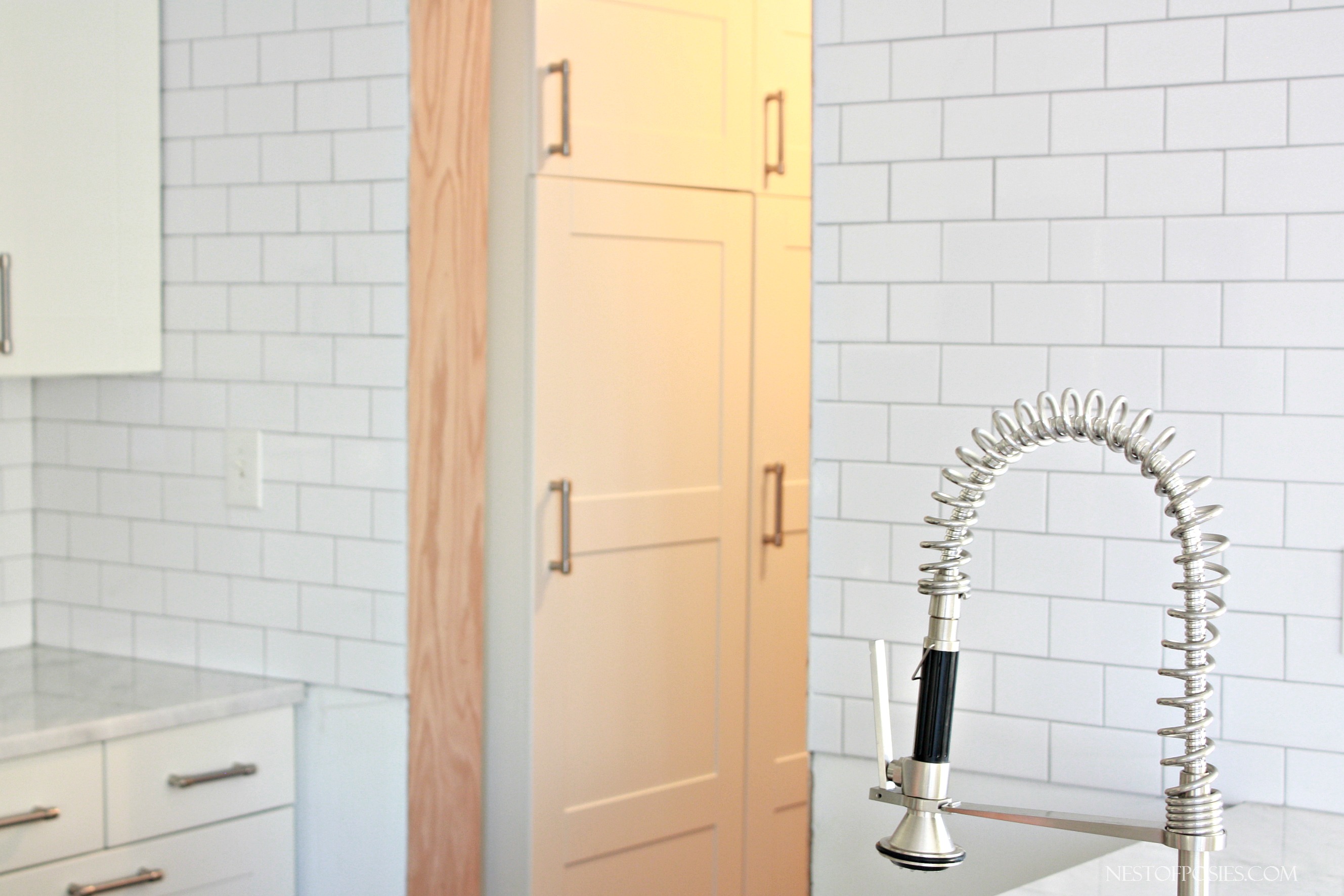 White Subway Tile going up the wall in the kitchen